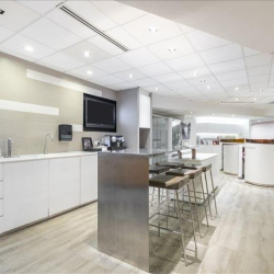 Modern office breakout area and kitchenette with white cabinetry at Central Plaza, Wanchai, Hong Kong